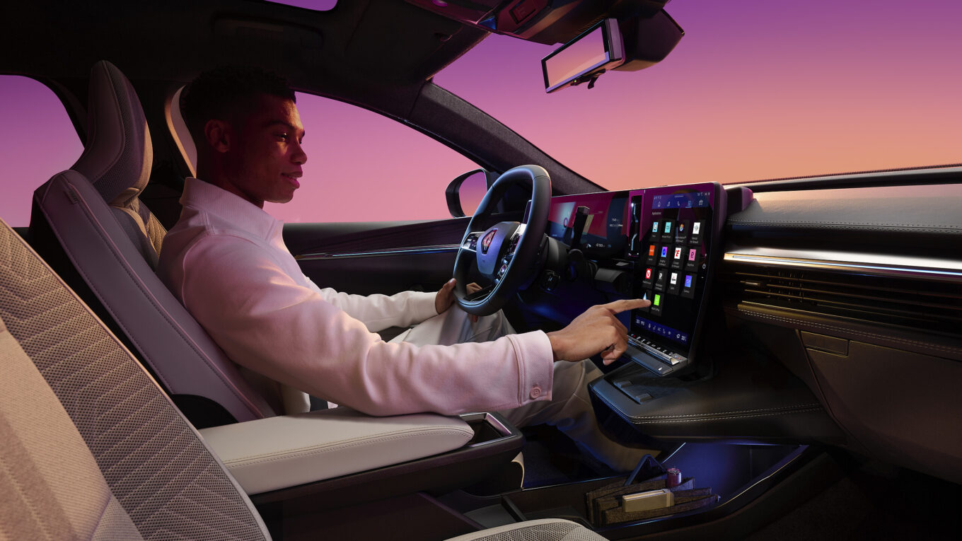 Conducteur jouant avec l'écran central du Scénic E-Tech electric